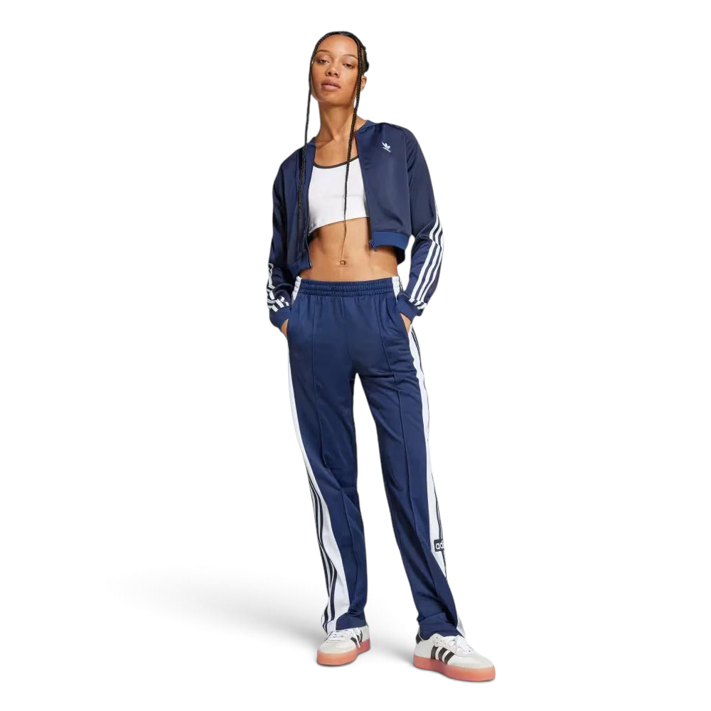 Person wearing a blue tracksuit with white stripes on a light gray background
