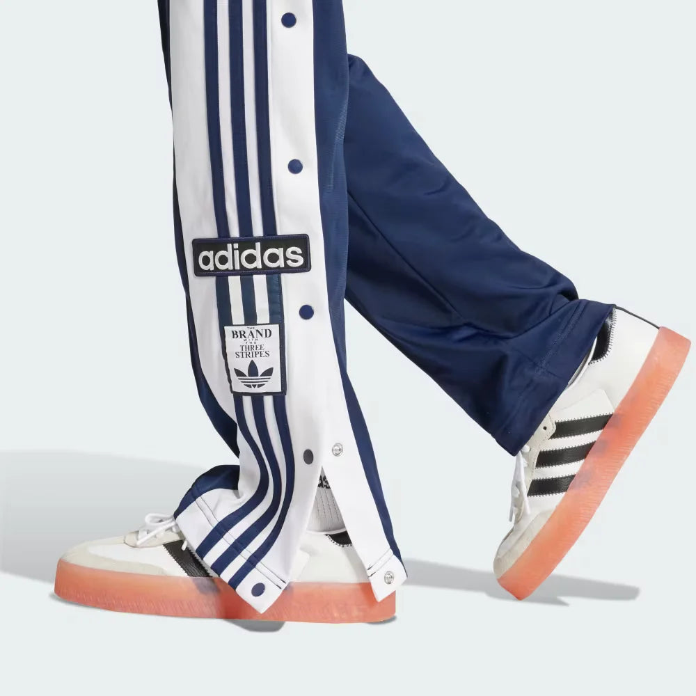 A close-up showing the bottom snap buttons opened to reveal a glimpse of the footwear underneath.