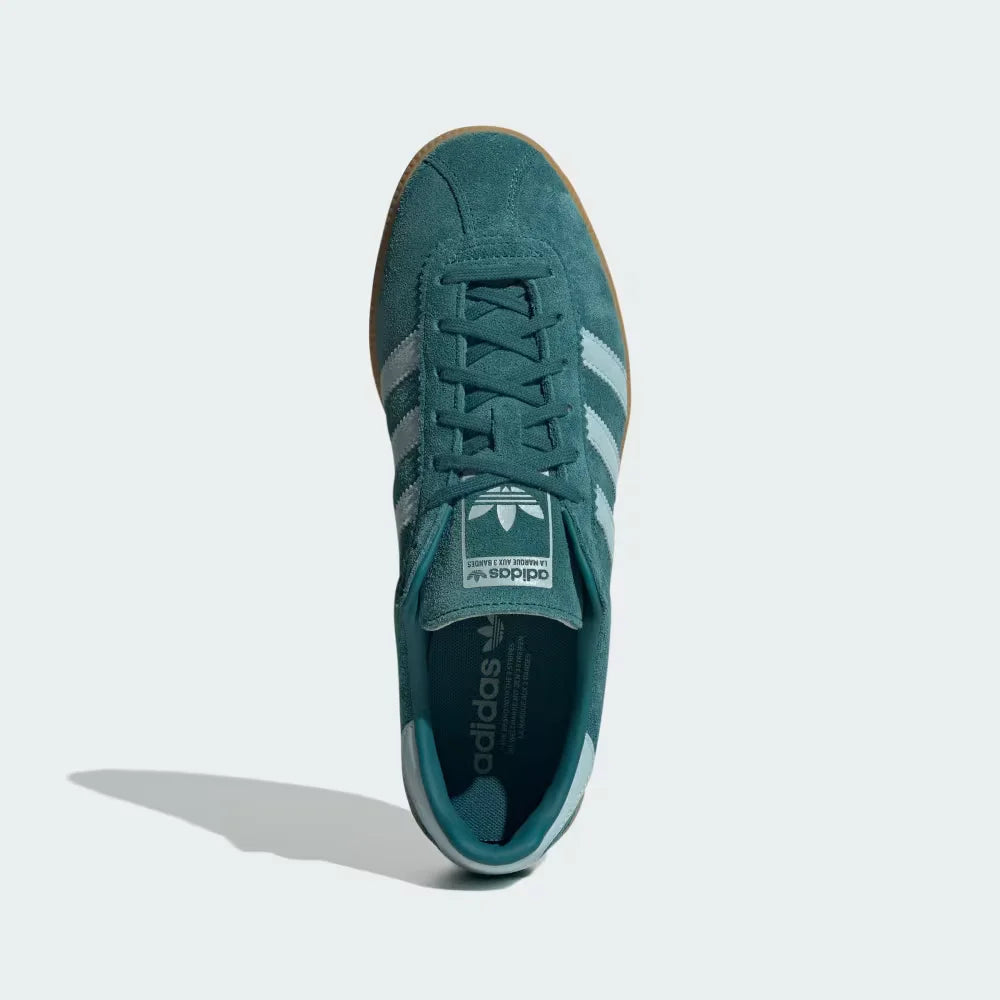 Looking down at the green suede lacing system and the tonal branding on the tongue.
