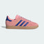 The Semi Pink Spark Gazelle, highlighting the deep Blue 3-Stripes and the slim, low-profile silhouette.