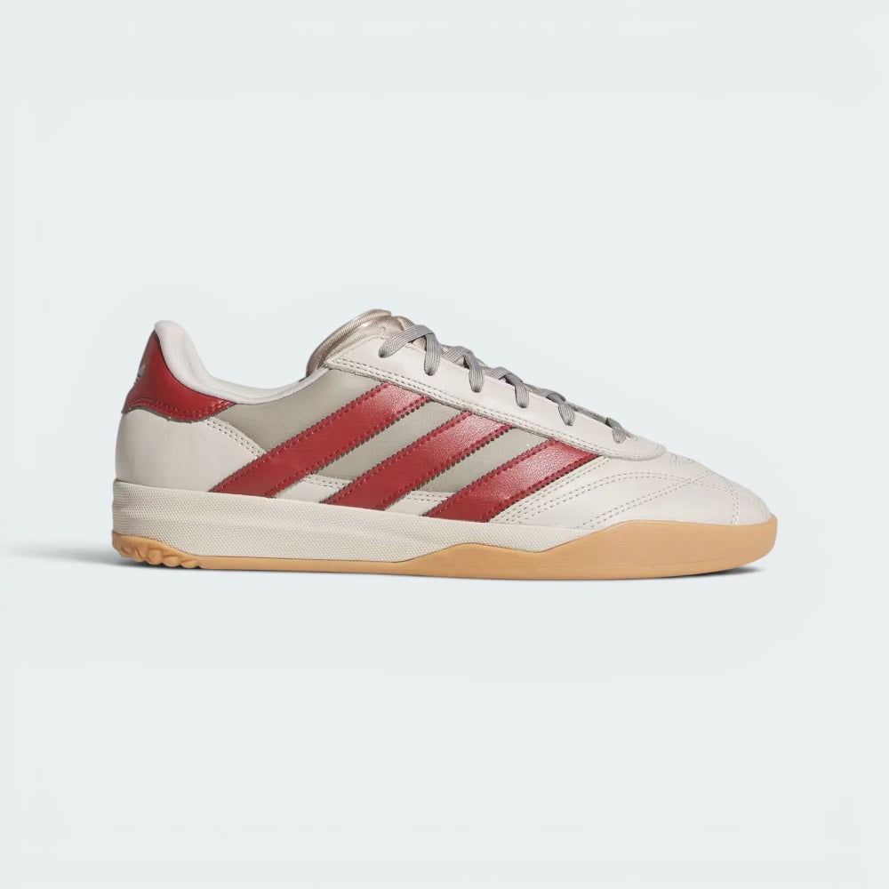 Highlights the high-velocity sweep of the Preloved Ruby 3-Stripes, the subtle gold-foil branding text, and the professional look of the textured gum rubber outsole walls.