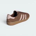 Focuses on the contoured shape of the Sandy Pink leather heel counter and the clean, stitched finish of the low-profile rubber sole.