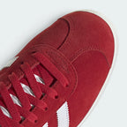 Details the premium dual-stitching lines across the velvety scarlet suede toe box and the clean eyelet configuration.