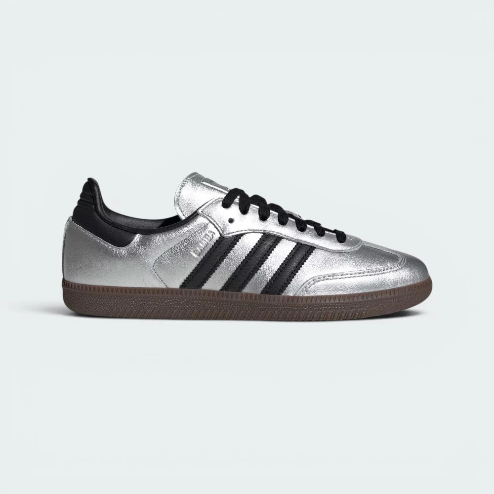 Highlights the high-velocity sweep of the Core Black serrated 3-Stripes and the professional, gleaming depth of the high-shine Silver Metallic leather panels catching the light.
