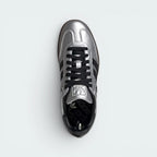 Focuses on the tidy lace closure, the clean alignment of the metallic silver tongue, and the iconic T-toe configuration covering the front box.