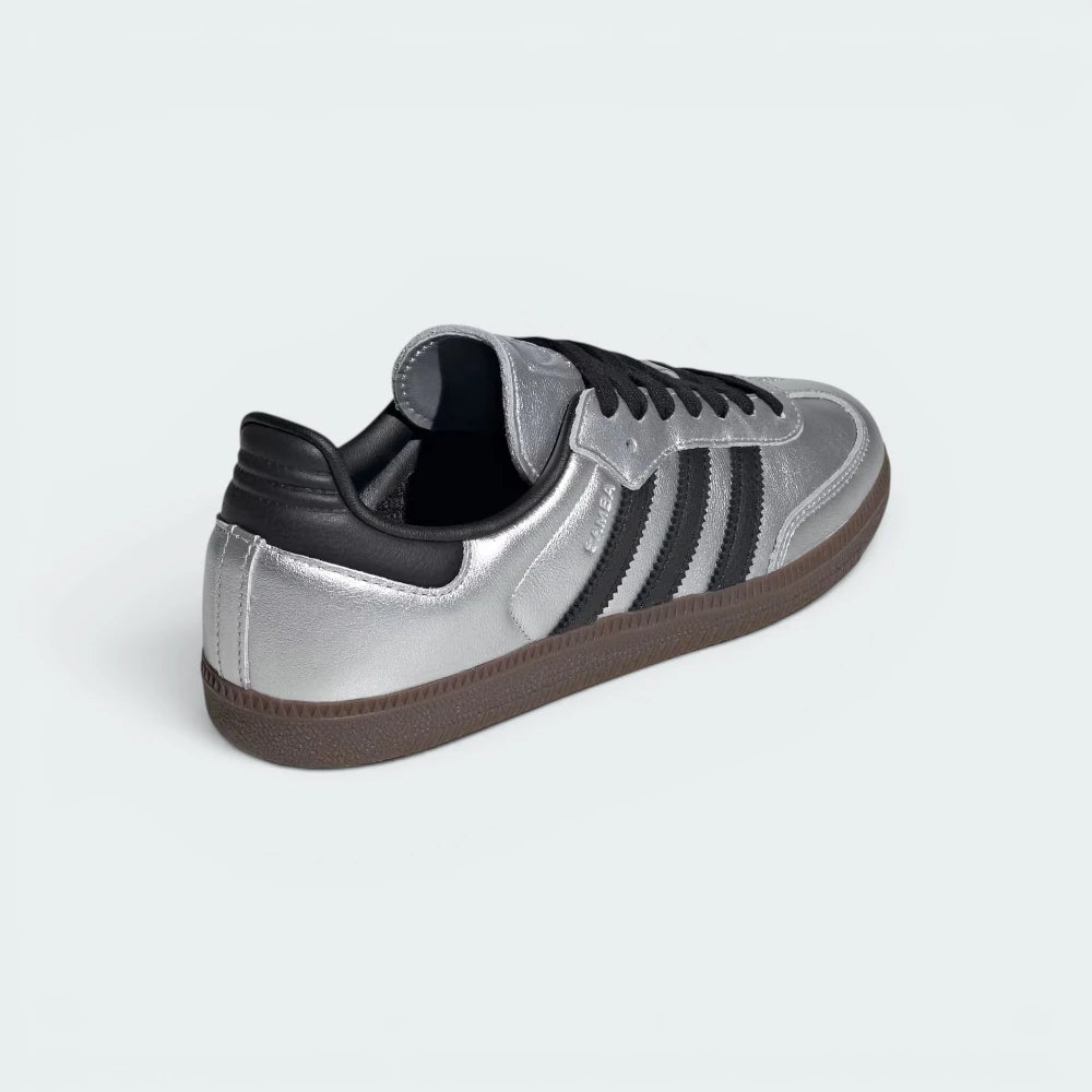Focuses on the contoured shape of the black leather heel tab and the clean finish of the low-profile gum rubber sole stitching.