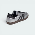 Focuses on the contoured shape of the black leather heel tab and the clean finish of the low-profile gum rubber sole stitching.