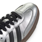 Details the premium stitching lines across the reflective silver T-toe panel and the precision lace eyelet configuration.