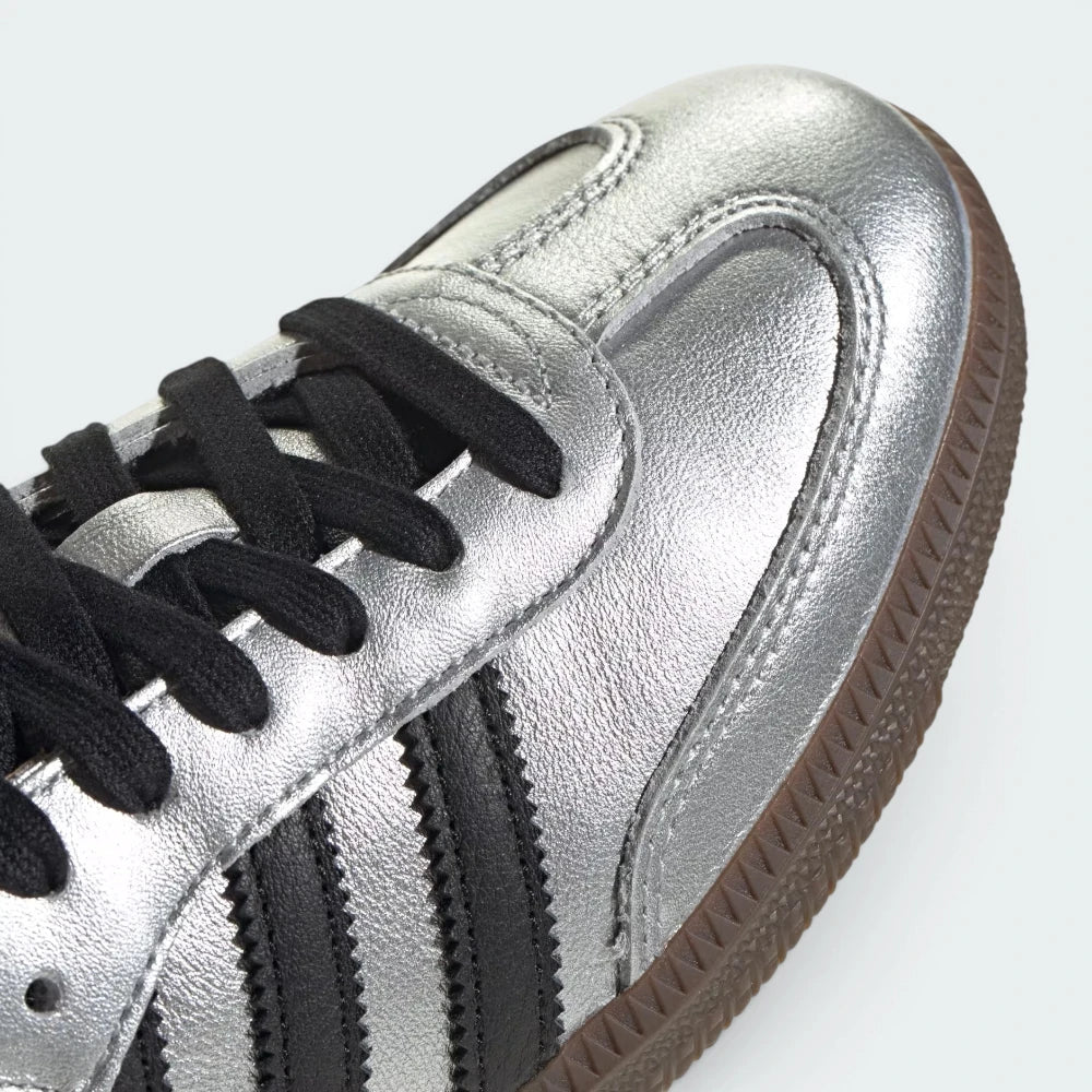 Details the premium stitching lines across the reflective silver T-toe panel and the precision lace eyelet configuration.
