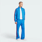 Man wearing a blue tracksuit with red accents on a white background