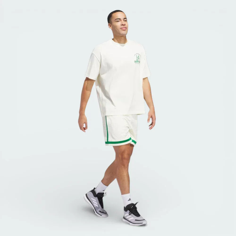 Three-quarter view of the tee, showcasing how the oversized cut drapes and the contrast between the Ivory body and Green details.