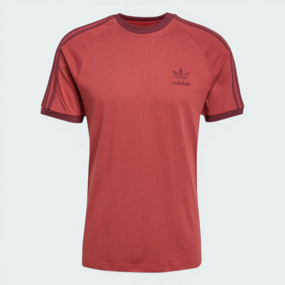Top-down view of the tee laid flat, highlighting the contrast white ribbed crewneck and the embroidered Trefoil logo.