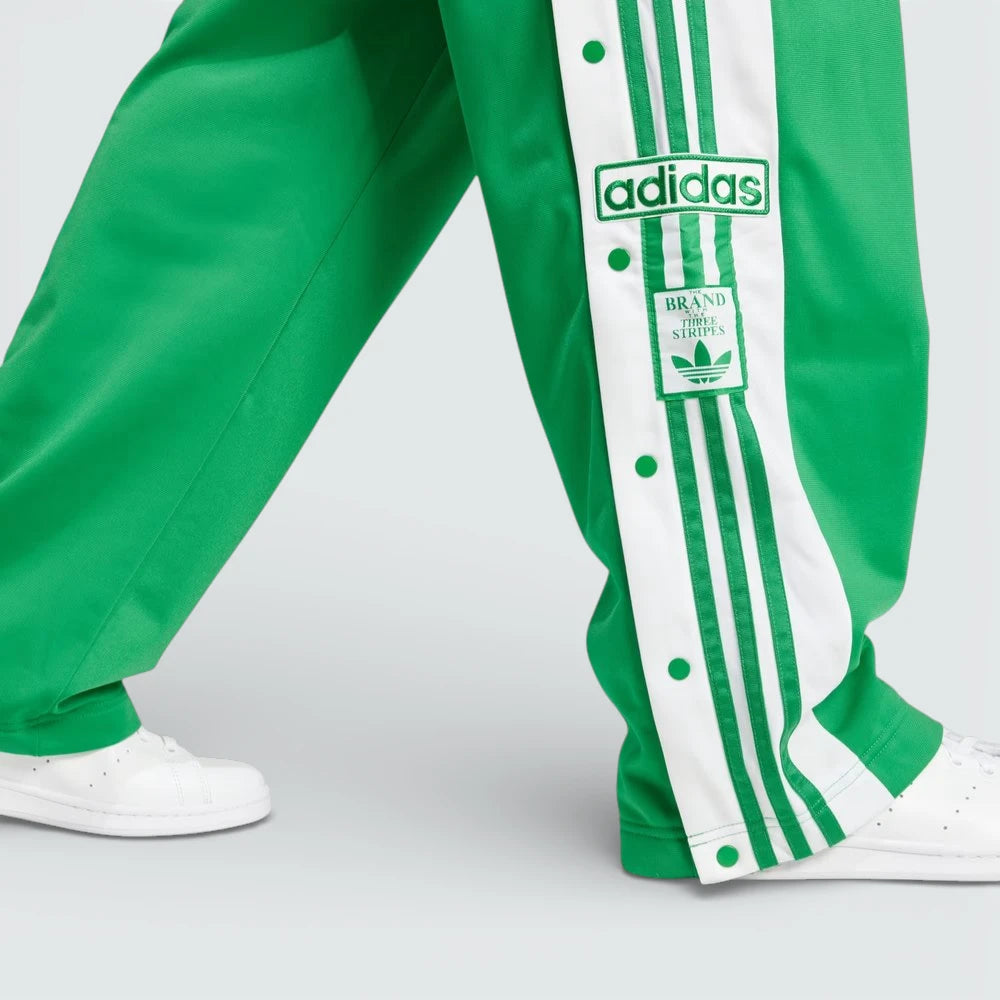 Close-up of the lower leg, focusing on the woven Adibreak patch and the high-quality metallic snap-button hardware