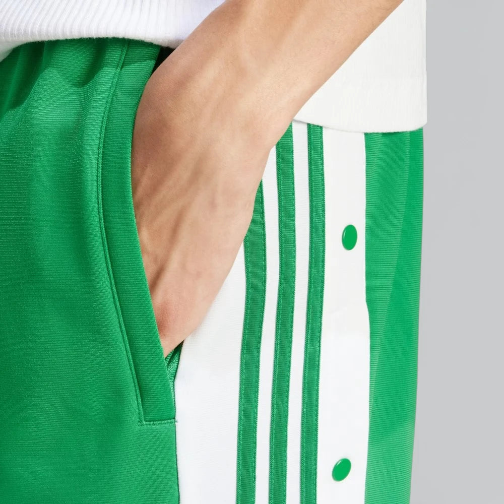 Zoom Side profile of the Green Adibreak pants, the open zip pockets, stripes and buttons. 