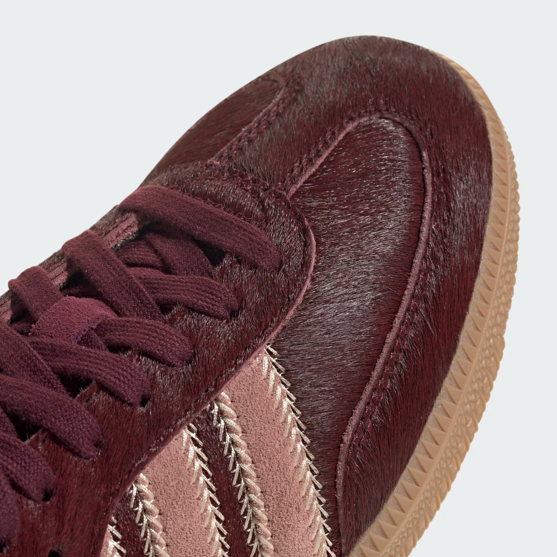 Details the premium stitching lines across the textured T-shaped toe box and the precision lace configuration.