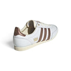 Focuses on the rear profile, highlighting the Preloved Brown leather heel tabs printed with metallic Trefoil logos and the slim cream rubber heel wraps.