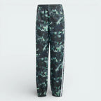 Forward profile of the adidas x Minecraft track pants, showing the colour gradient from light grey to dark green and the woven twill texture.