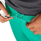 Close-up focus on the matching green elastic waistband and the adjustable woven drawcord tied neatly at the front.