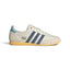Highlights the sleek, low-profile lateral view showing the off-white perforated leather upper, deep Preloved Ink navy adidas Three Stripes, double-stitched T-toe overlay, Orange Tint accent paneling, and slim rubber sole.