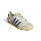 Emphasising the low-slung, athletic silhouette and the clean visual harmony between the off-white leather chassis and dark navy stripe overlays.