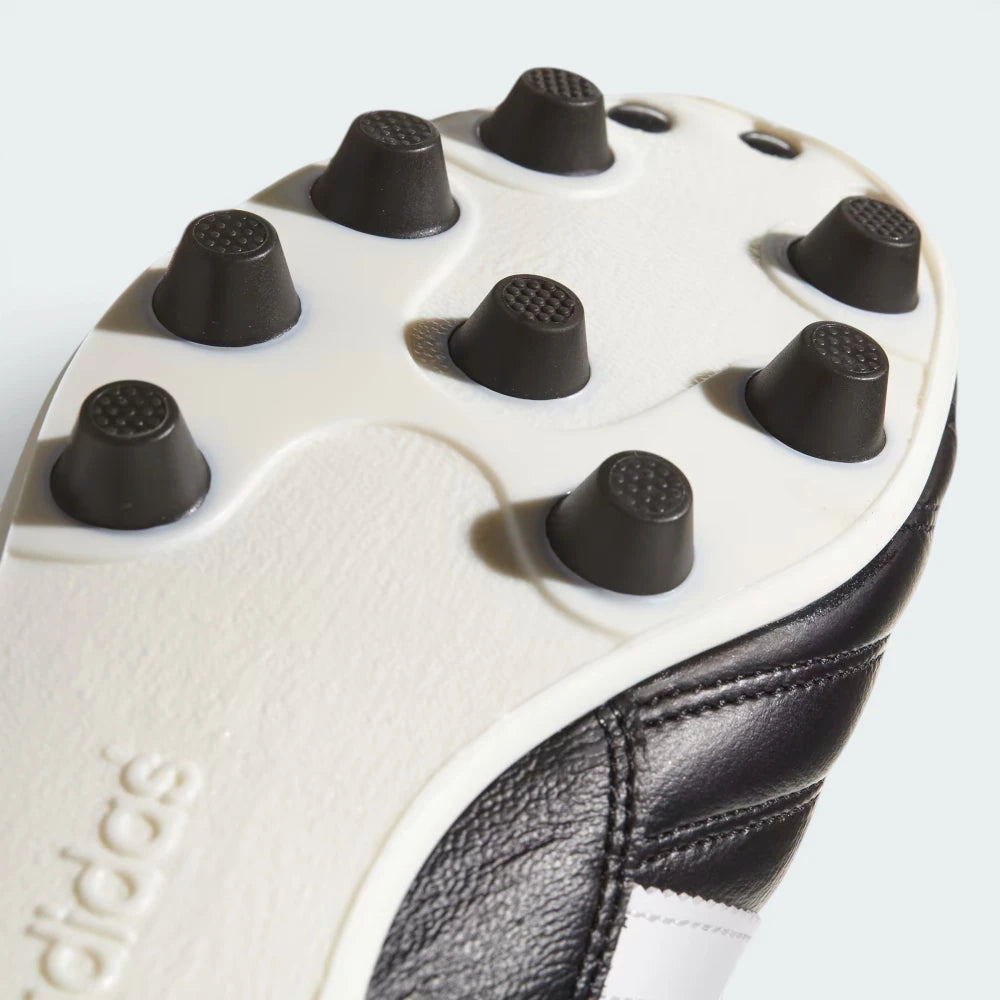 Close-up of Adidas soccer cleats showing tread pattern and brand logo.