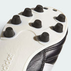 Close-up of Adidas soccer cleats showing tread pattern and brand logo.