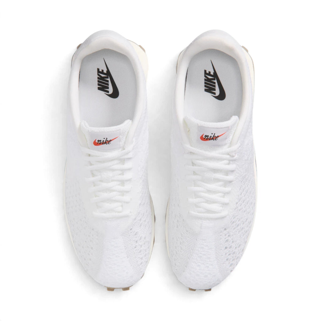 Overhead view of both sneakers showing the adaptive white knit forefeet, central lacing systems, and white insoles printed with black Nike branding.