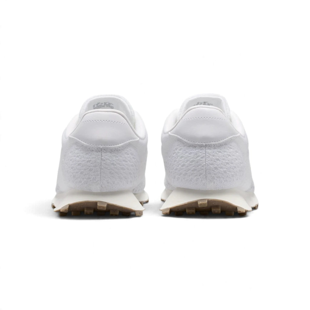 Rear view of the sneakers emphasizing the smooth leather heel tabs, flared sail midsoles, and brown waffle outsole edges.