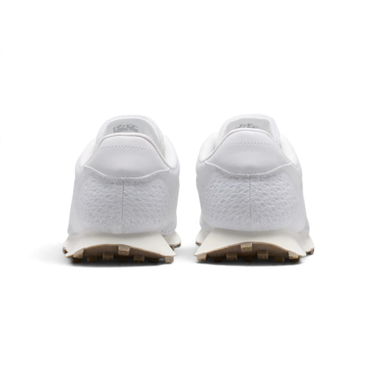 Rear view of the sneakers emphasizing the smooth leather heel tabs, flared sail midsoles, and brown waffle outsole edges.