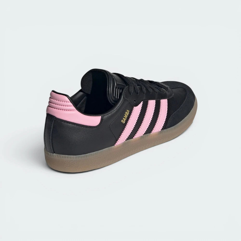 Focuses on the contoured shape of the pink leather heel tab and the clean, stitched finish of the low-profile gum sole casing.