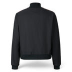 Rear-facing studio perspective of the black track jacket, showcasing the clean unbranded back panel, smooth twill fabric drape, and ribbed hem band.