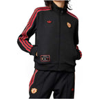 Studio front product shot of the adidas Manchester United Icon Track Top for women in black, highlighting the full-zip closure, ribbed stand-up collar, red-and-white 3-Stripes sleeve taping, embroidered Trefoil logo, and vintage Manchester United club badge.