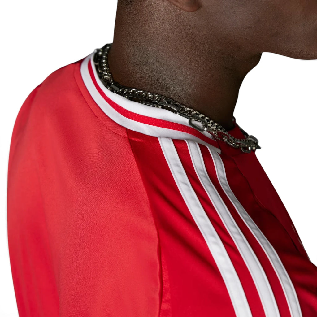 Macro close-up angle capturing the textured fabric weave, precision stitching of the embroidered Manchester United club badge, and the structured collar trim.