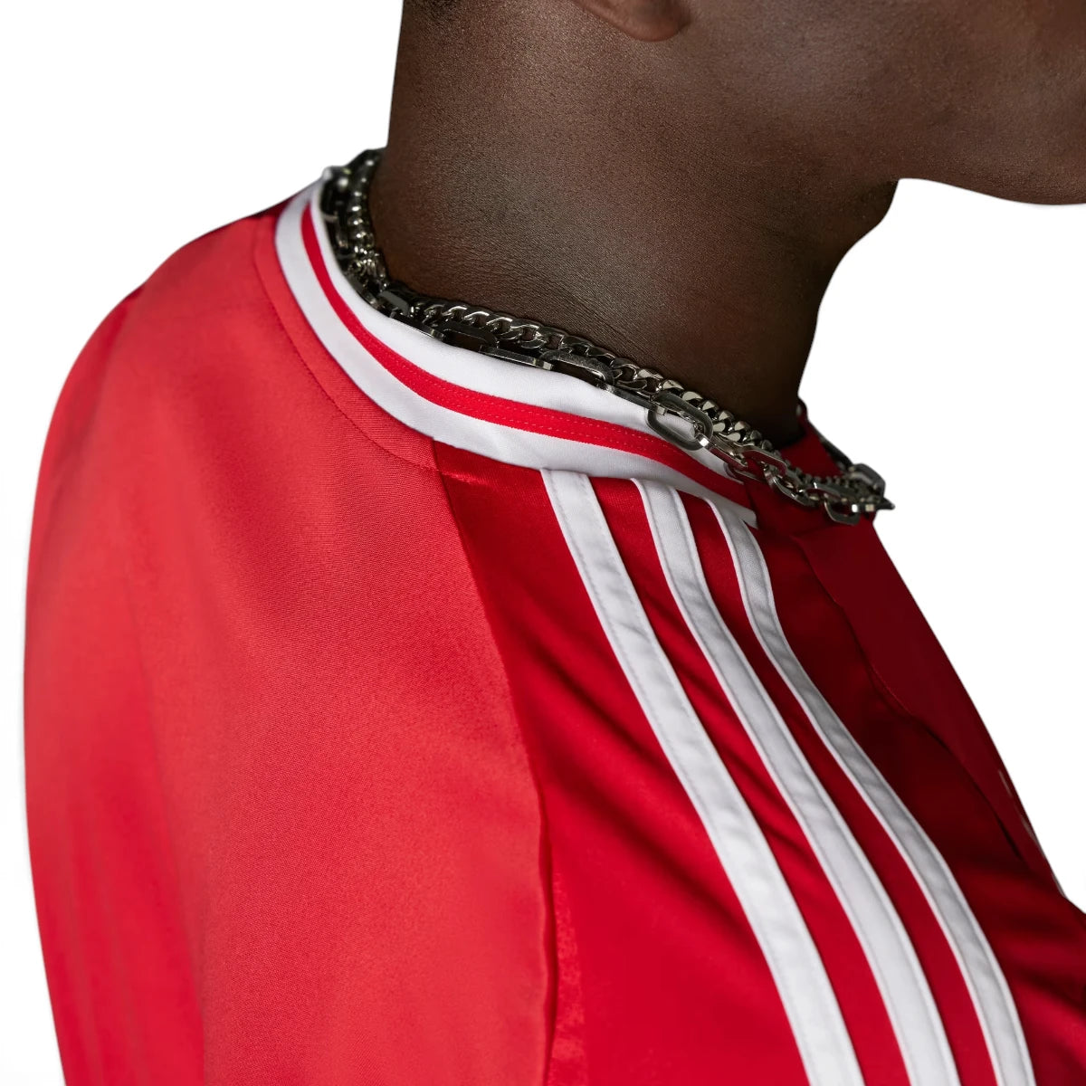 Macro close-up angle capturing the textured fabric weave, precision stitching of the embroidered Manchester United club badge, and the structured collar trim.