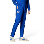 The Bold Blue track pants, highlighting the slim-cut leg and the vintage white Adidas 3-Stripes.
