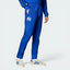The Bold Blue track pants, highlighting the slim-cut leg and the vintage white Adidas 3-Stripes.