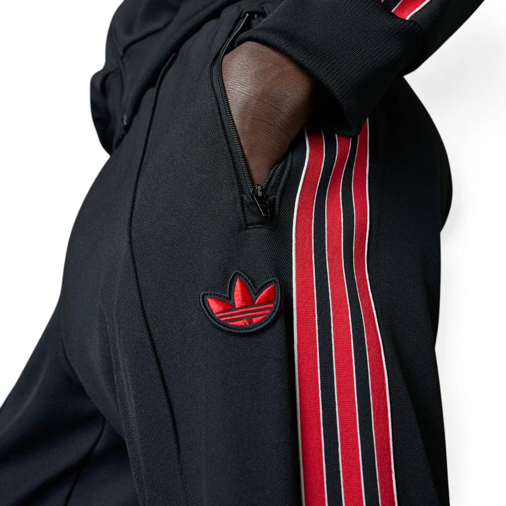 Detailed close-up angle capturing the secure front zipper pocket hardware and the embroidered red adidas Trefoil logo positioned neatly on the hip.