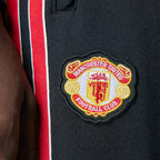 Macro close-up focus on the intricate embroidery and scalloped border of the vintage Manchester United football club crest.