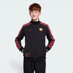 Child wearing a black tracksuit with red stripes on a white background