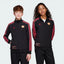 Two children wearing black tracksuits with red stripes and logos on a white background