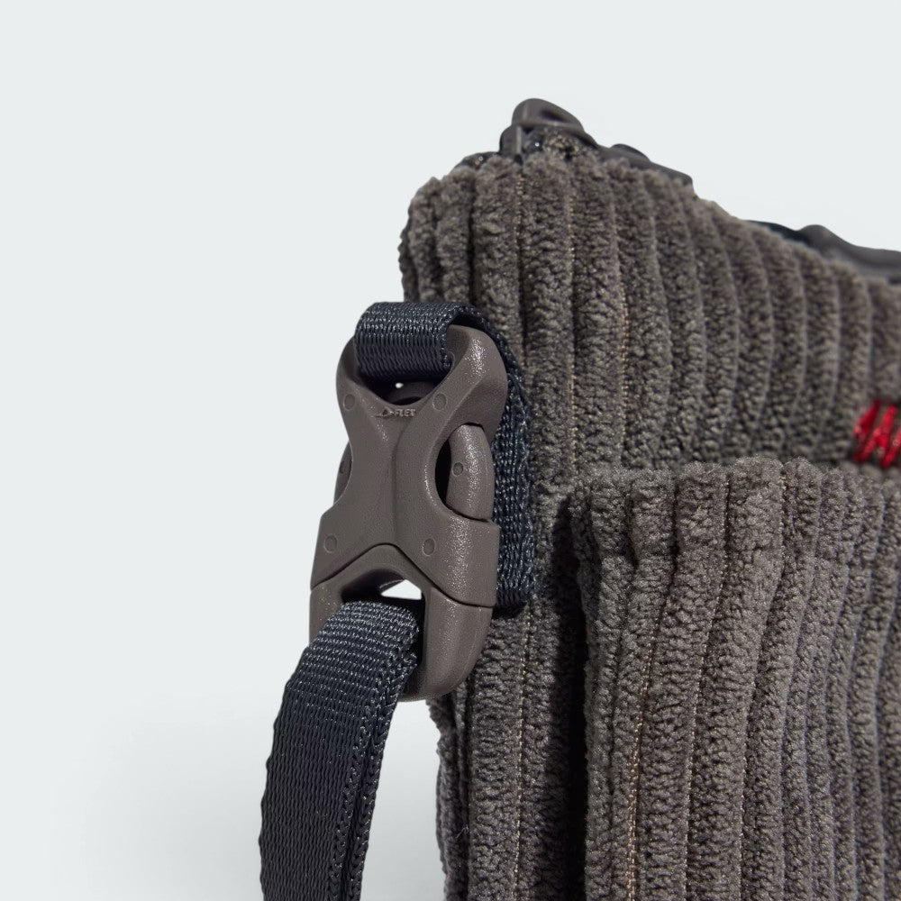 Highlights the technical strap adjusters and the "unreal" finish of the corduroy ribs.