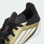 Detailed zoom on the sole of the Adidas Messi F50 League FG/MG Juniors' boots, highlighting the FG/MG stud pattern and cushioned midsole.