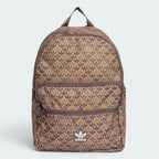 Focuses on the full front dimensional view, showcasing the sharp contrast of the iconic white printed retro Trefoil logo badge against the repeating, two-tone brown monogram background canvas.