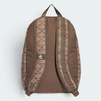 Focuses on the contoured shape of the solid brown back panel, highlighting the repeating monogram patterning lining the upper face of the adjustable shoulder straps.