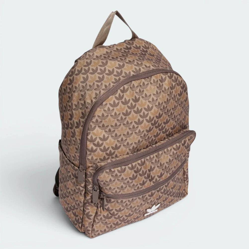 Highlights the backpack sitting at a three-quarter angle, showing the depth of the front zip pocket compartment and the streamlined slip-in pocket on the flank.