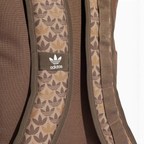 Highlights a close-up of the adjustable shoulder straps, showing the fabric weave texture, the integrated monogram graphics, and the stitched-on fabric tab featuring the classic white adidas Trefoil emblem.
