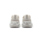 Focuses on the rear profile, highlighting the supportive heel counter, subtle pull tab details, and the wide, stacked footprint of the ReactX foam midsole base.
