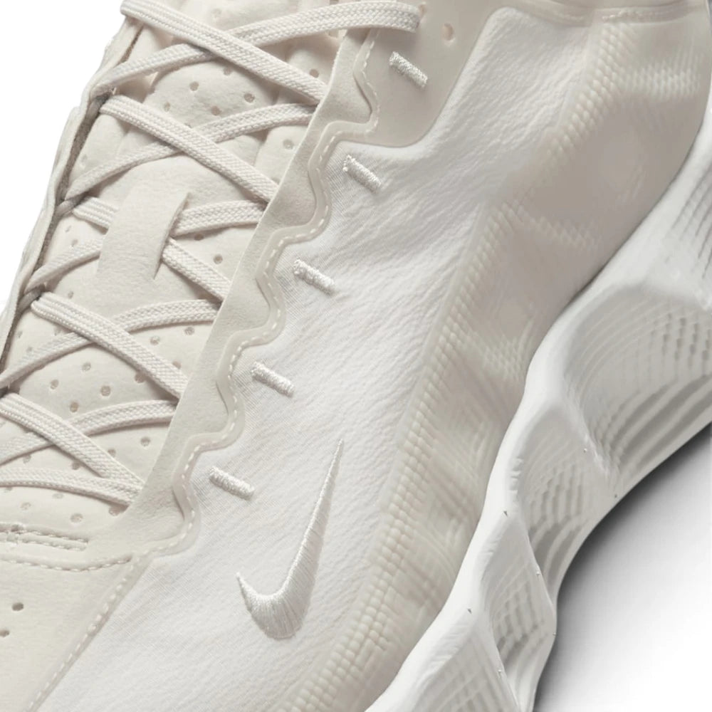 Close-up of a Nike sneaker in a monochromatic off-white color, showing the textured upper, laces, and the embossed Swoosh logo.