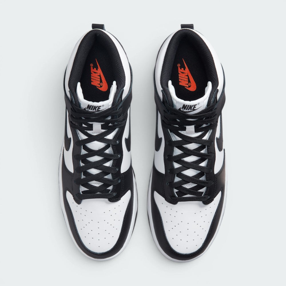 Focuses on the locked-in central lacing layout, displaying the symmetry of the white nylon tongue, black laces, black "NIKE" tongue patch, perforated toe box, and Total Orange "NIKE" branding printed on the black insoles.