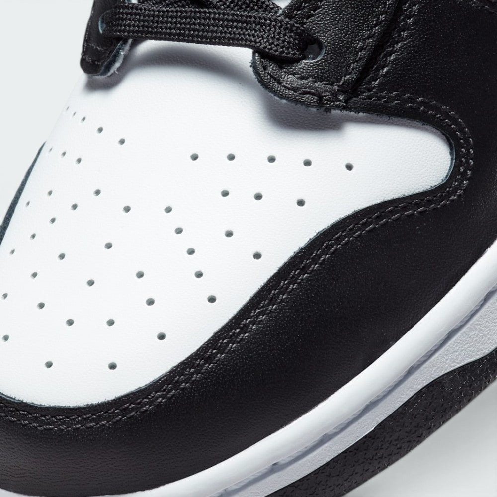 Details the micro-precision of the perforated white leather toe box, showing the double-stitched black toe mudguard and the neat tracking of the black laces.